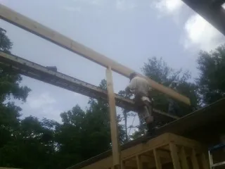 Carpenter setting a ridge beam over a new addition frame — Ice Dam Removal by Roofing Brothers in Taos