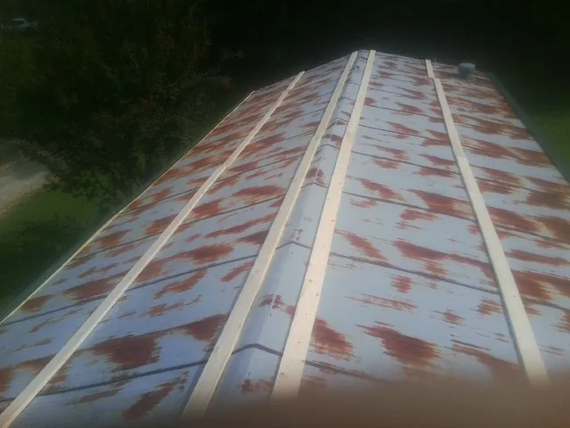 Rusted metal roof panels with new wood purlins before replacement — Storm Damage Roof Repair in Taos by Roofing Brothers