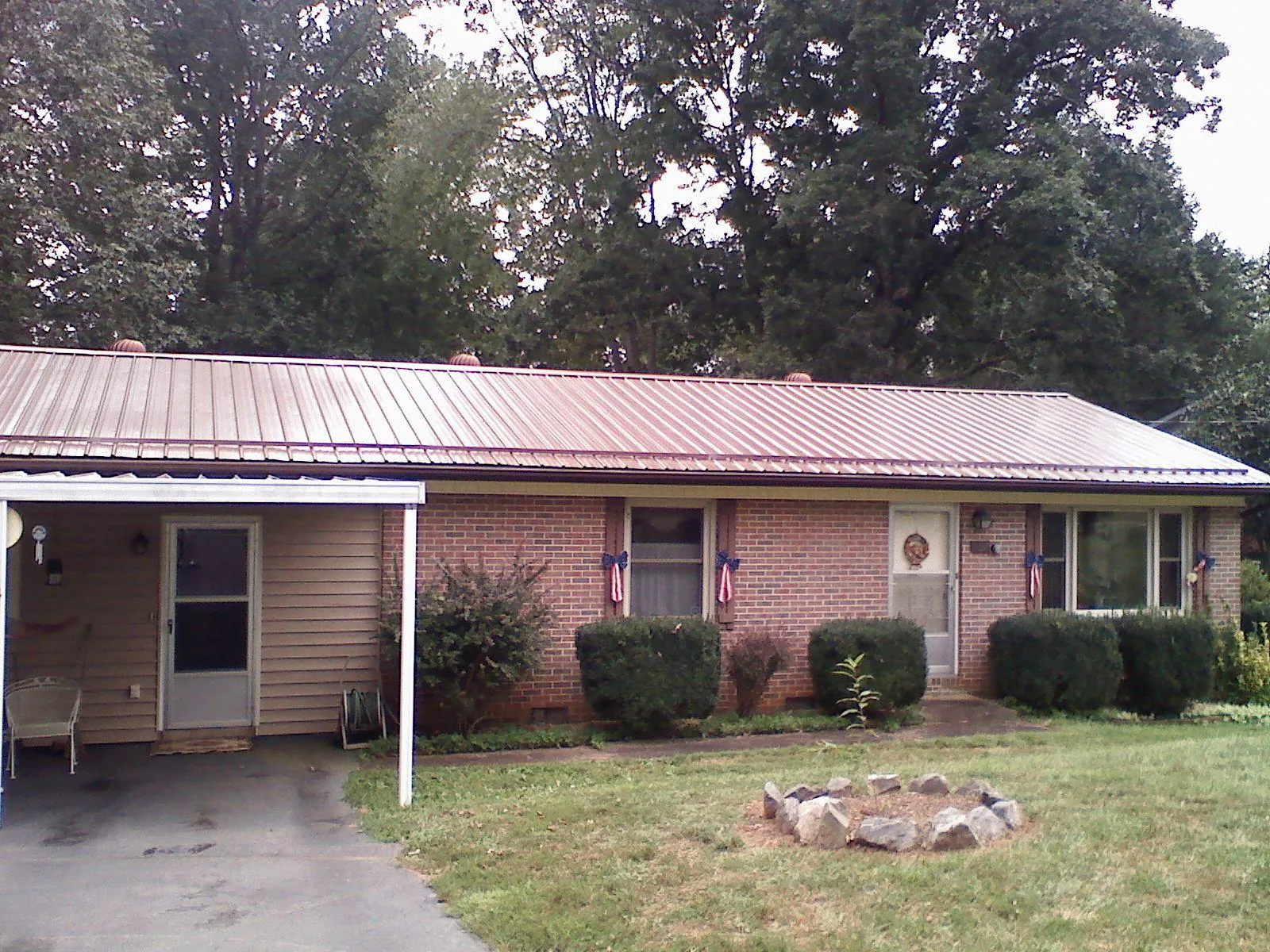 Bronze metal roof and carport on a brick ranch home — Roof Repair work by our crew in Taos